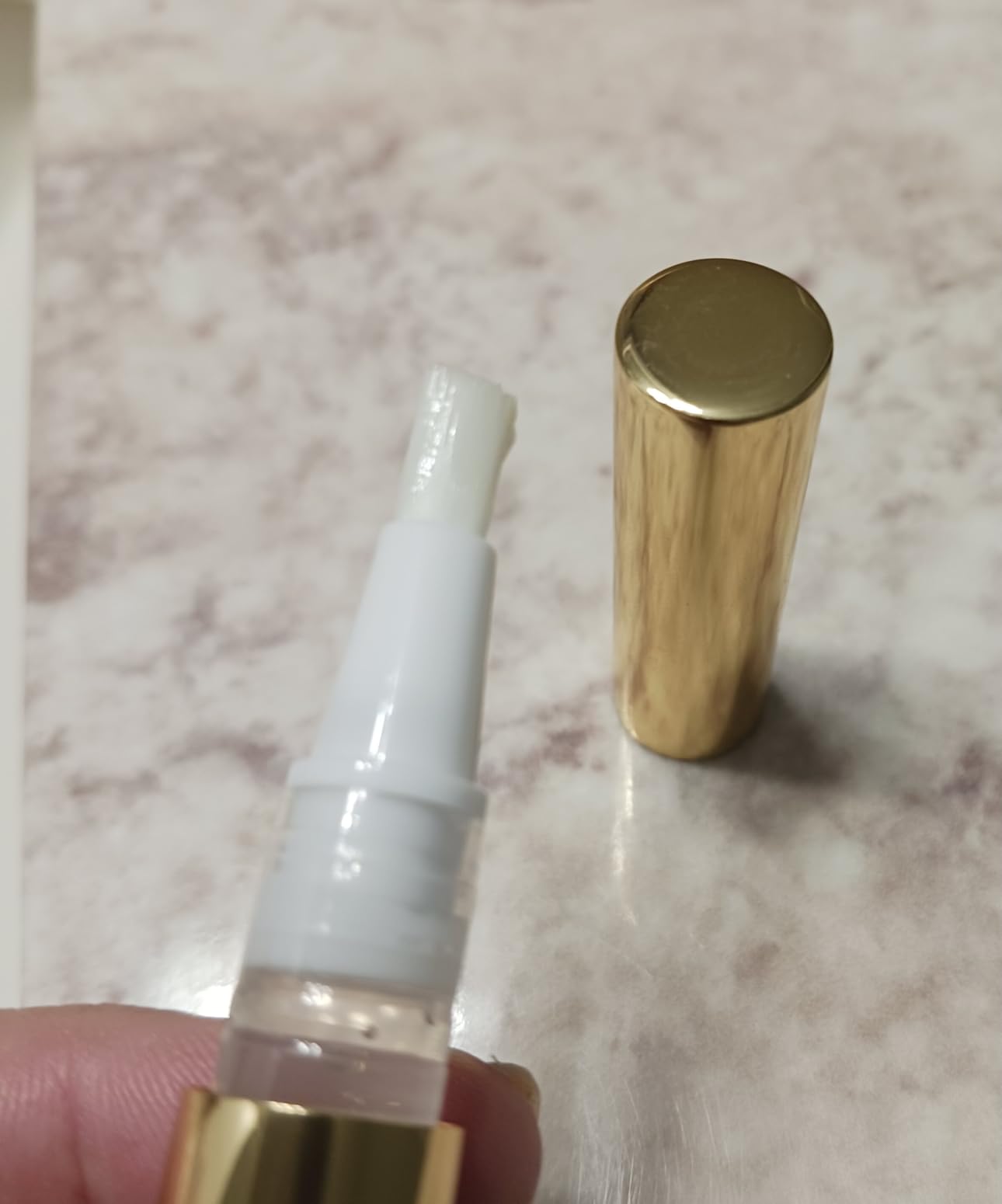 Close-up of Snow Gold Whitening Pen and applicator – used overnight for whiter smile without sensitivity