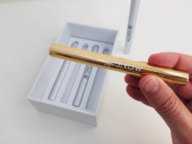 Customer holding Snow Gold Teeth Whitening Pen – better than whitening strips
