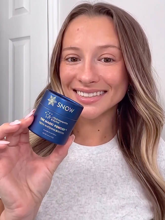 Woman smiling and holding the Purple Magic Powder jar