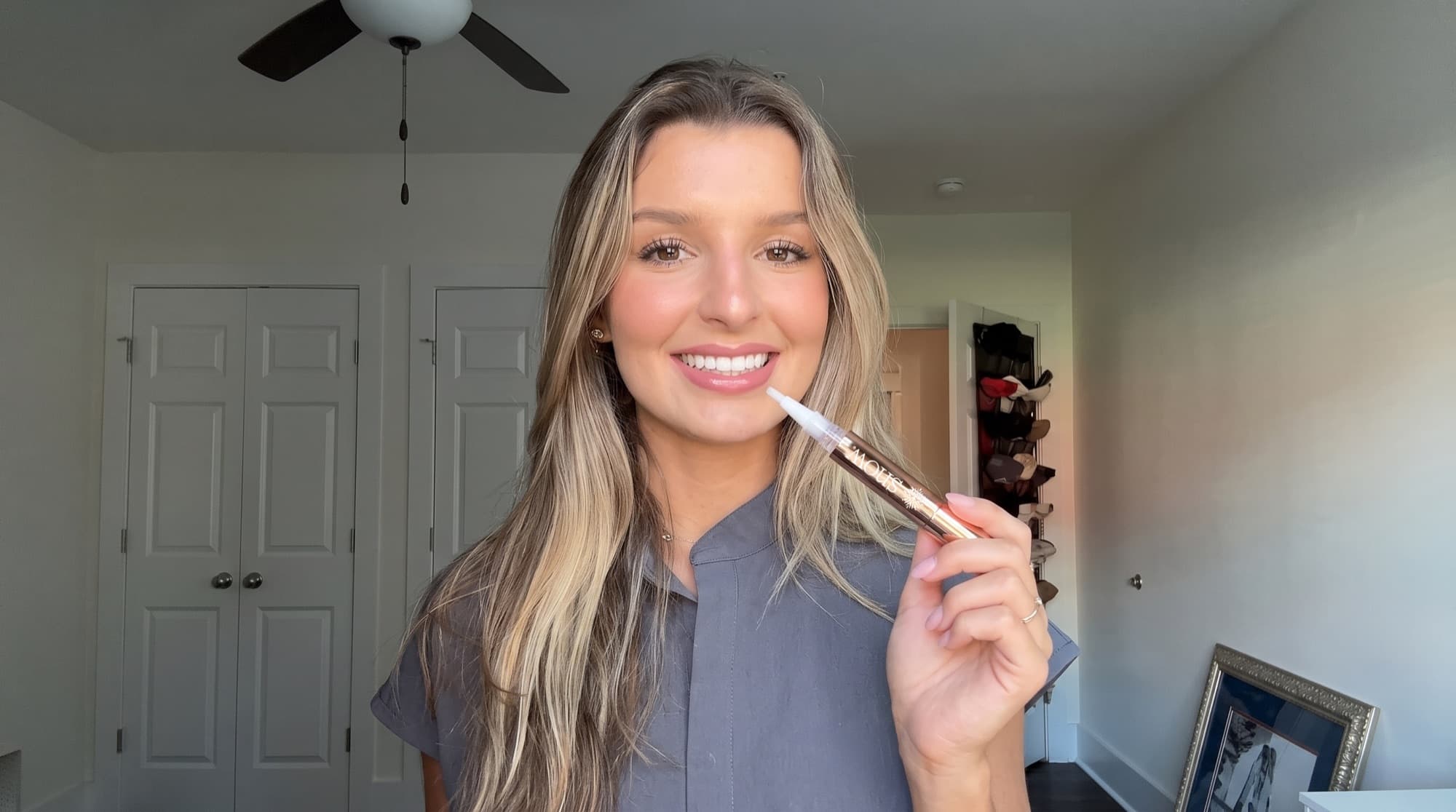 Smiling woman holding a SNOW whitening pen